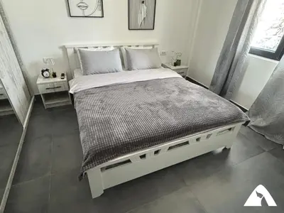 a bedroom with a large bed with a gray comforter at Apartman ZAM in Kopaonik