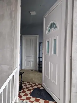 a hallway with a white door and a checkered floor at Apartman VRANJANKA in Vranje