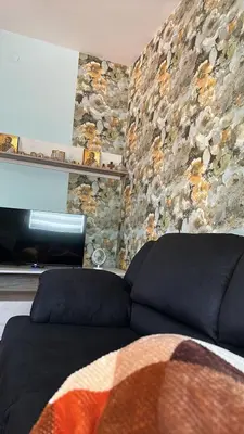a couch in a room with a stone wall at Apartman Teodora in Jagodina