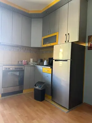 a kitchen with white cabinets and a refrigerator at Apartman Teodora in Jagodina