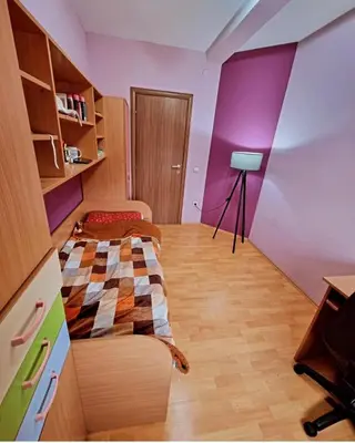 a bedroom with a bed and a purple wall at Apartman Teodora in Jagodina