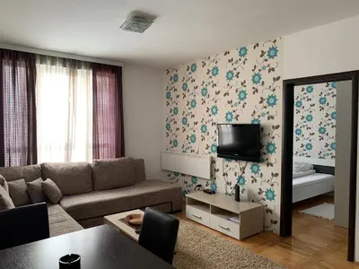 a living room with a couch and a tv at Apartman 34, Kraljevi čardaci in Kopaonik