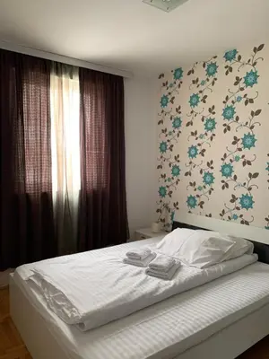 a bedroom with a bed with blue flowers on the wall at Apartman 34, Kraljevi čardaci in Kopaonik