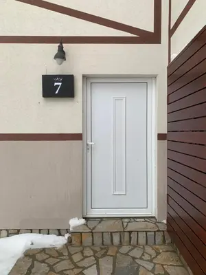 a white door on a building with a sign on it at Apartman 34, Kraljevi čardaci in Kopaonik