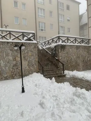 a street light covered in snow next to a building at Apartman 34, Kraljevi čardaci in Kopaonik