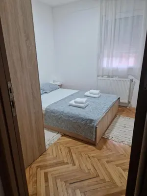 a bedroom with a bed with two towels on it at Apartman DRINA in Vranje