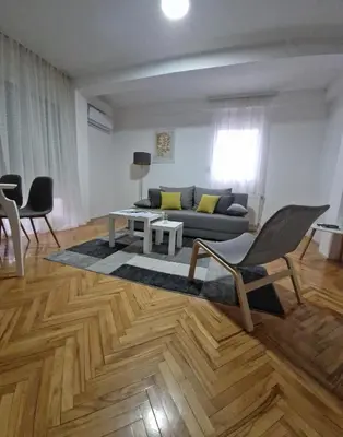 a living room with a couch and a table and chairs at Apartman DRINA in Vranje