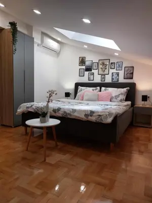 a bedroom with a large bed and a table at Heart of the city in Niš