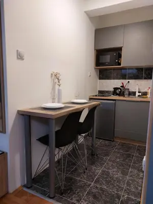 a small kitchen with a table and two chairs at Heart of the city in Niš
