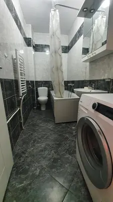 a bathroom with a washing machine and a toilet at Heart of the city in Niš
