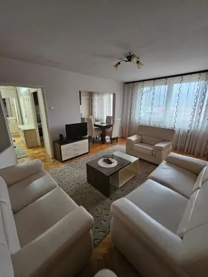 a living room with white couches and a table at Apartman Maks 1 in Pirot