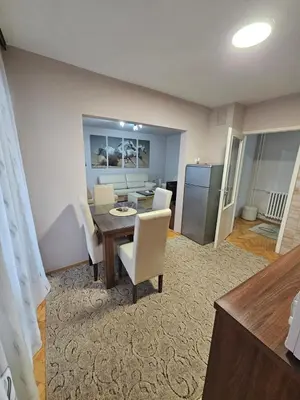 a dining room with a table and white chairs at Apartman Maks 1 in Pirot