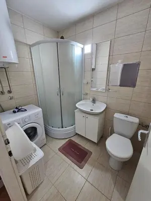 a bathroom with a toilet sink and a washing machine at Apartman Maks 1 in Pirot