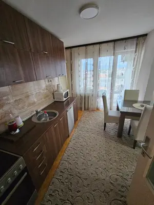a kitchen with a sink and a table and a dining room at Apartman Maks 1 in Pirot