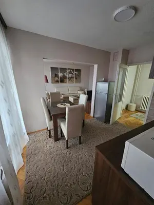 a living room with a dining room table and chairs at Apartman Maks 1 in Pirot