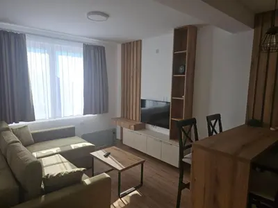 a living room with a couch and a tv and a table at Pogled Contra in Kopaonik