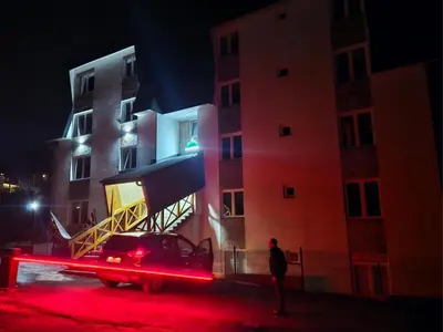 a car parked in front of a building at night at Pogled Contra in Kopaonik