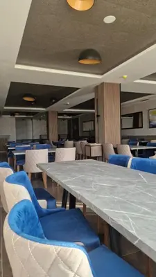 a large table with blue chairs in a room at Mokoš apartman, Residence hill A35, minimum dve noći in Kopaonik