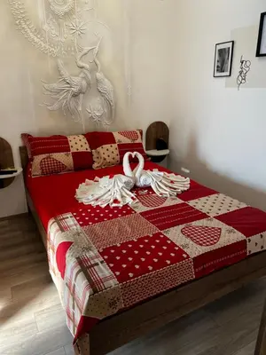 a bed with a red and white quilt on it at Angelina Art in Trnava