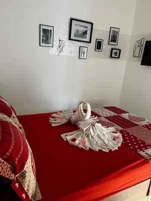 a bedroom with a bed with red sheets and pictures at Angelina Art in Trnava