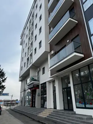 a tall white building with windows on a street at Angelina Art in Trnava