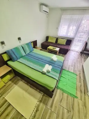 a bedroom with a large green bed and a couch at Vila Aleksandra 2 Studio 5 in Soko Banja