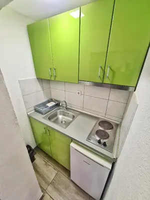 a small kitchen with green cabinets and a sink at Vila Aleksandra 2 Studio 5 in Soko Banja