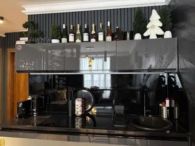 a kitchen with a sink and a shelf with wine bottles at Black Elegant & Spa Kop in Kopaonik