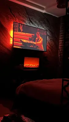 a living room with a fireplace and a tv on a wall at Black Elegant & Spa Kop in Kopaonik