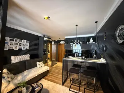 a living room with a couch and a kitchen at Black Elegant & Spa Kop in Kopaonik