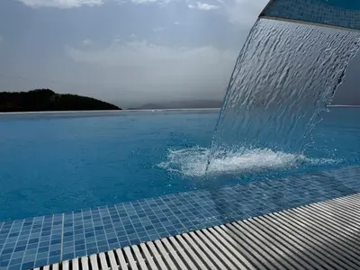a water fountain in the middle of a swimming pool at Black Elegant & Spa Kop in Kopaonik