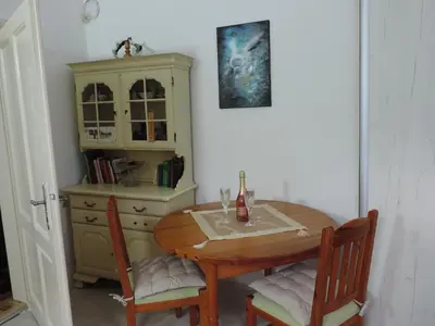 a dining room table with two chairs and a dresser at Apartman - kuca za odmor Slatina in Vrnjačka Banja