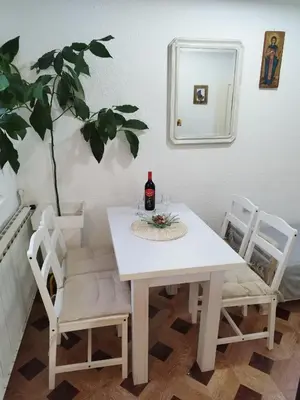 a white table with two chairs and a bottle of wine at Apartman - kuca za odmor Slatina in Vrnjačka Banja