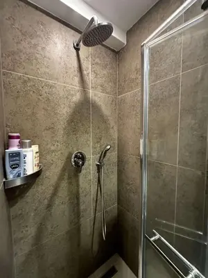 a shower with a glass door in a bathroom at Konaci 25 Kopaonik in Kopaonik