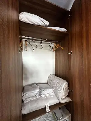 a room with a closet with a bed and towels at Konaci 25 Kopaonik in Kopaonik