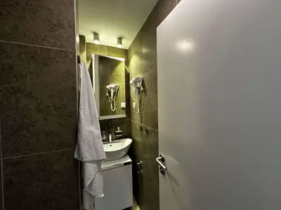a bathroom with a sink and a mirror at Konaci 25 Kopaonik in Kopaonik