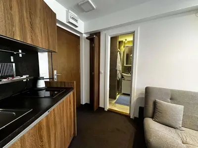 a kitchen with a sink and a door to a bathroom at Konaci 25 Kopaonik in Kopaonik