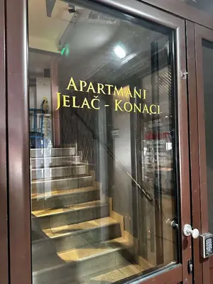 a reflection of a staircase in a glass door at Konaci 25 Kopaonik in Kopaonik