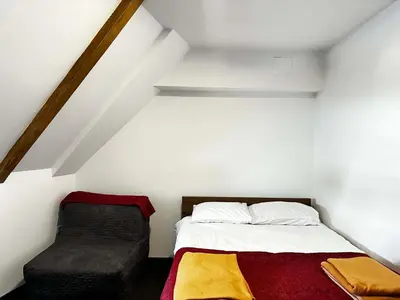 a bedroom with a bed and a chair at Konaci 25 Kopaonik in Kopaonik