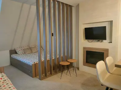 a bedroom with a bed with a fireplace and a tv at Apartmani Iva Kop Konaci Koznik402 in Kopaonik