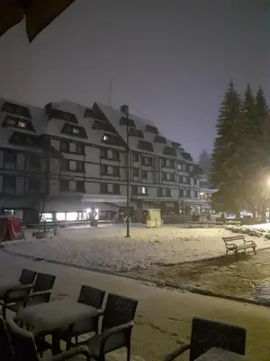 a large building with snow on it at night at Apartmani Iva Kop Konaci Koznik402 in Kopaonik