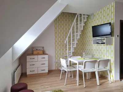 a dining room with a table and a tv on a wall at Apartman R&M Kraljevi čardaci in Kopaonik