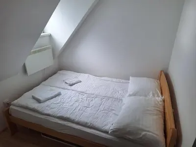 a bed with white sheets and towels on it in a room at Apartman R&M Kraljevi čardaci in Kopaonik