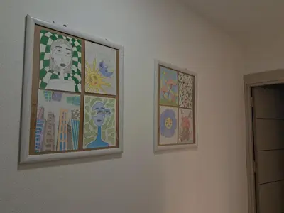 two pieces of art on a white wall at La pera Kruševac in Kruševac