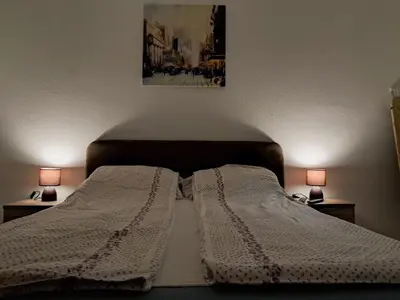 a bed with two white blankets and two lamps at La pera Kruševac in Kruševac