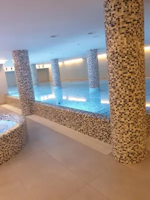 a swimming pool with blue water in a building at Exclusive apartmants 1 Vrnjacka Banja in Vrnjačka Banja