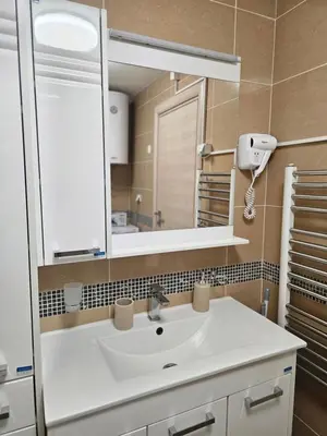 a bathroom with a white sink and a mirror at Exclusive apartmants 1 Vrnjacka Banja in Vrnjačka Banja