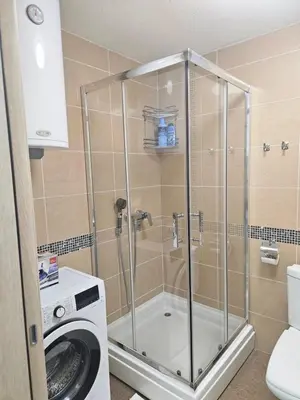 a shower in a bathroom with a washing machine at Exclusive apartmants 1 Vrnjacka Banja in Vrnjačka Banja