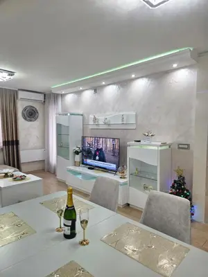 a living room with a table with wine glasses and a christmas tree at Exclusive apartmants 1 Vrnjacka Banja in Vrnjačka Banja