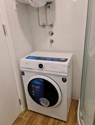 a washer and dryer in a small room at Beril lux apartman in Jagodina